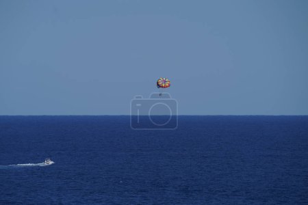 Photo for Parasailing in a blue sky in Palm Beach, Florida. Parasailing is a popular recreational activity among tourists in Florida - Royalty Free Image