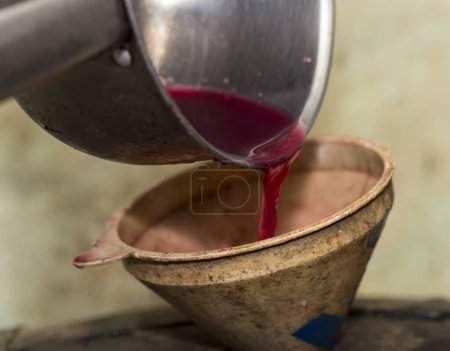 Foto de Elaboración. El jugo de uva fresca se vierte a través de un embudo en un barril. Cosecha en casa. Tecnología de la producción de vino en Moldova. - Imagen libre de derechos