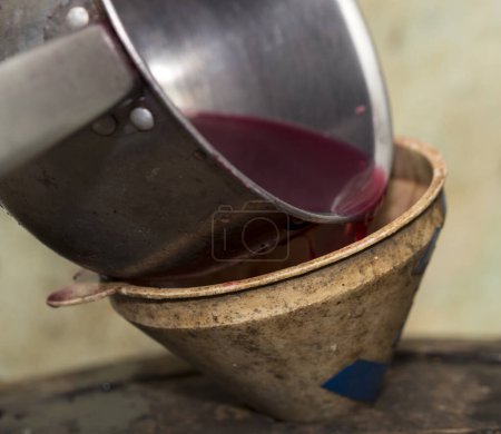 Foto de Elaboración. El jugo de uva fresca se vierte a través de un embudo en un barril. Cosecha en casa. Tecnología de la producción de vino en Moldova. - Imagen libre de derechos