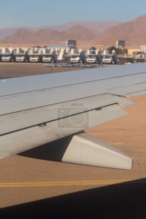 L'avion atterrit sur l'aérodrome. Détendeurs et volets bord de fuite lors de l'atterrissage. Vue de la terre depuis l'aile de l'avion. Sinaï. Sharm El Sheikh, Égypte.