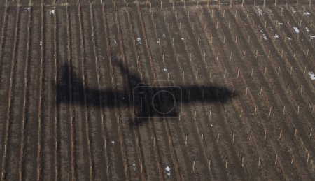 The shadow of an airplane on the ground during landing. A bird's-eye view of the earth.
