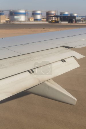 El avión aterriza en el campo de aviación. Spoilers y aletas de borde de arrastre al aterrizar. Vista de la tierra desde el ala del avión. Sinaí. Sharm El Sheikh, Egipto.