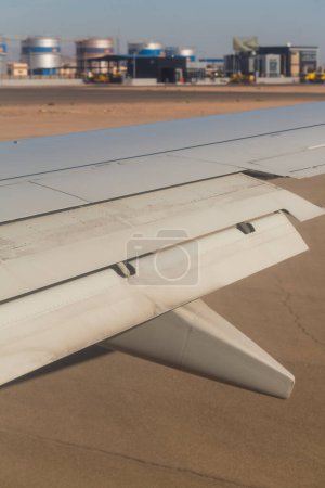 Das Flugzeug landet auf dem Flugplatz. Spoiler und Klappen bei der Landung am Hinterkopf. Blick von der Tragfläche des Flugzeugs auf die Erde. Sinai. Sharm El Sheikh, Ägypten.
