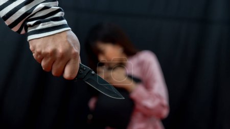 Photo for Thief is threatening woman. Robber is robbing woman by knife. A man robs a woman on the street. The criminal  the man holding a Knife - Royalty Free Image