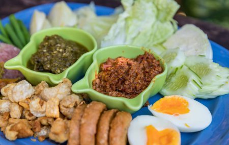 Photo for Tradition Northern Thai food. Spicy Northern Thai Pork and Tomato thai name is "Nam Prik Ong". Local food in thailand. deep fried pork skin. - Royalty Free Image