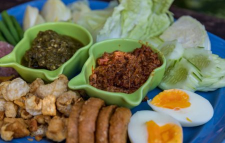 Photo for Tradition Northern Thai food. Spicy Northern Thai Pork and Tomato thai name is "Nam Prik Ong". Local food in thailand. deep fried pork skin. - Royalty Free Image