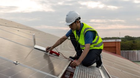Téléchargez les photos : Configuration de travail de l'ingénieur Panneau solaire sur le toit. Ingénieur ou travailleur travaillent sur des panneaux solaires ou des cellules solaires sur le toit du bâtiment commercial - en image libre de droit