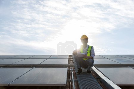 Foto de Configuración de trabajo del ingeniero Panel solar en la azotea. Ingeniero o trabajador trabaja en paneles solares o células solares en el techo del edificio de negocios - Imagen libre de derechos