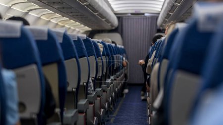 Foto de Passenger seat. Interior of airplane with passengers sitting on seats. Plane cabin. The interior of the aircraft with passengers on seats. - Imagen libre de derechos