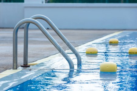 Téléchargez les photos : Main courante en acier inoxydable pour la descente dans la piscine. Piscine avec rampe. Échelle d'une piscine. Plan horizontal. escalier piscine. Échelle en acier inoxydable - en image libre de droit