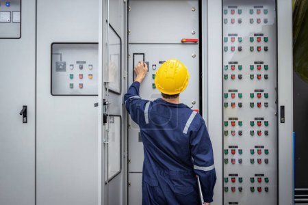 Photo for Electrical engineer working in control room. Electrical engineer man checking Power Distribution Cabinet in the control room - Royalty Free Image