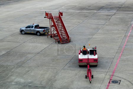 Photo for Airplane tow tractor at the airport apron near the terminal. Aircraft Towing Tractor.  A towing tractor belonging in air port is being operated by officer. Aerodrome tow tractor is driving at airport - Royalty Free Image