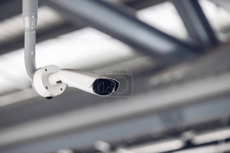 Online-Überwachungskamera CCTV-Überwachungssystem im Freien des Hauses. Ein verschwommenes nächtliches Stadtbild. Moderne CCTV-Kamera in Echtzeit auf einem Mast. Gerätesystemservice für Lebensdauer oder Anlagevermögen.