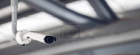 Online-Überwachungskamera CCTV-Überwachungssystem im Freien des Hauses. Ein verschwommenes nächtliches Stadtbild. Moderne CCTV-Kamera in Echtzeit auf einem Mast. Gerätesystemservice für Lebensdauer oder Anlagevermögen.