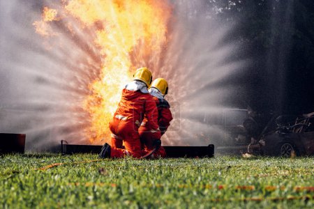 Firefighter Concept. Several firefighters go offensive for a fire attack. Fireman using water and extinguisher to fighting with fire flame. 