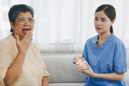 Zahnärztin in Zahnarztpraxis spricht mit Seniorin und bereitet sich auf Behandlung vor. Ein Zahnarzt im Gespräch mit einer Seniorin in der Zahnarztpraxis.