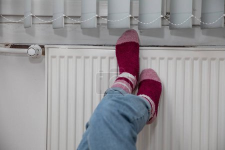 Téléchargez les photos : Chauffage des pieds. Chauffage central efficace dans votre propre maison. La période hivernale est une période d'augmentation de la consommation d'énergie, en particulier pour le chauffage de la maison. - en image libre de droit
