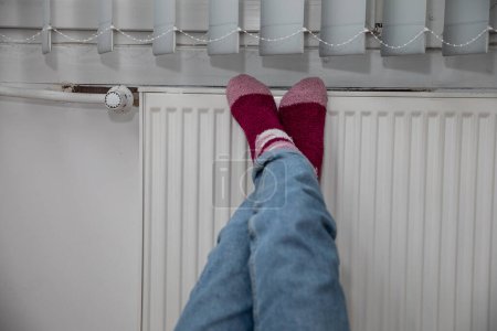 Téléchargez les photos : Chauffage des pieds. Chauffage central efficace dans votre propre maison. La période hivernale est une période d'augmentation de la consommation d'énergie, en particulier pour le chauffage de la maison. - en image libre de droit