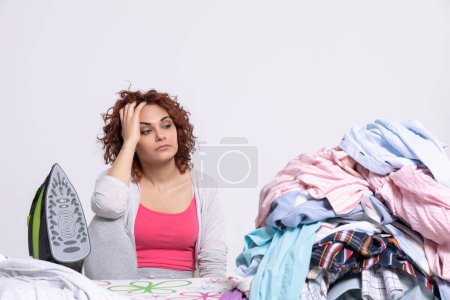 Foto de Today a dozen mens shirts went from the laundry to the ironing board. The girl is completely deflated and is offended at the whole world. - Imagen libre de derechos