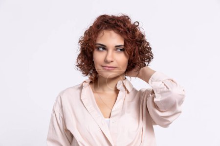 Photo for A gentle smile on her face. A European woman with chestnut-colored hair. A girl with fair skin and curly short hair looks straight ahead. - Royalty Free Image