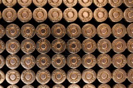 Foto de Multiple cartridges stacked one next to the other as seen from the primer side. Sharp small arms ammunition. Top view. - Imagen libre de derechos