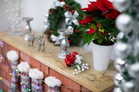 Foto de Chimenea con tabla de madera y medias de invierno. Decoración de Navidad en la chimenea de ladrillos. - Imagen libre de derechos