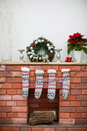Foto de Decoración en el estante de madera. Chimenea hecha de ladrillos y calcetines calientes. - Imagen libre de derechos