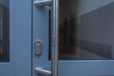Photo for Gray aluminum door with stainless steel metal entablature and lock cylinder installed. Close-up view of selected components. - Royalty Free Image