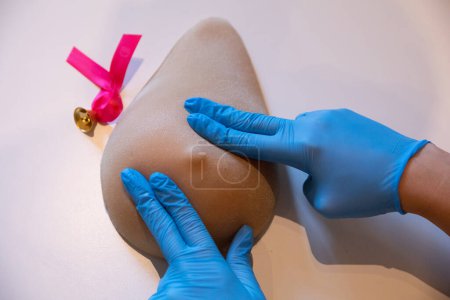 Foto de Técnicas de colocación de dedos durante el examen mamario en el fantasma de Lady M. Demostración profesional de la técnica de compresión mamaria durante el examen. - Imagen libre de derechos
