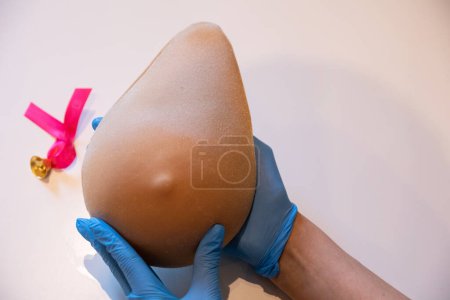 Photo for Demonstration of how to examine your breast with one hand on the phantom of Lady M. Professional demonstration of breast compression technique during the examination. - Royalty Free Image