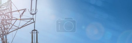 Foto de Un poste eléctrico sobre un fondo en tonos azules y el sol y la lente brillan en una vista panorámica. - Imagen libre de derechos