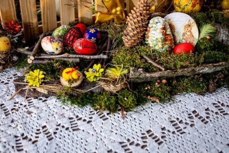 Photo for On a bed of lush moss, twigs and birch bark intertwine with vibrant greenery, forming a rustic backdrop for colorful Easter eggs. Among them, one bears the joyful inscription of , Alleluia, adding a - Royalty Free Image