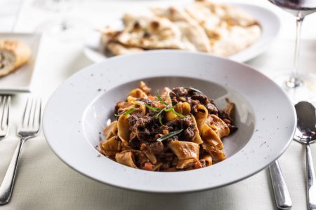 Photo for Papardelle al cinghiale, a Sienese typical dish with game ragout in a plate. - Royalty Free Image