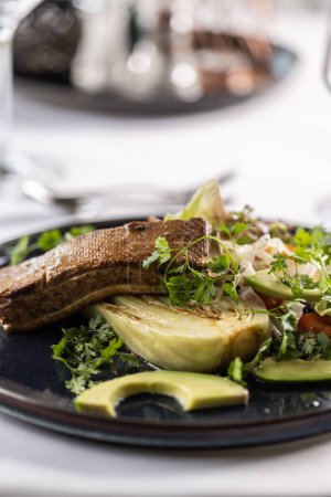 Foto de Tofu marinado encima de una ensalada con aguacate, alcachofa y verduras. - Imagen libre de derechos