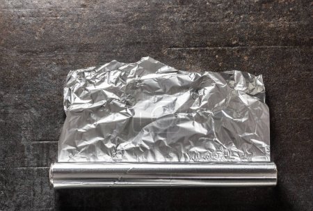 Papel de aluminio sobre fondo de hormigón oscuro.