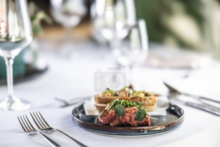 Téléchargez les photos : Tartare de steak avec pain grillé servi sur une table de restaurant. - en image libre de droit