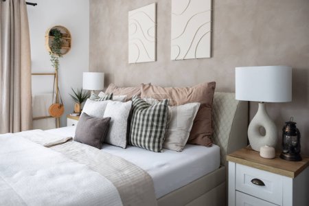 Foto de Interior moderno dormitorio, manta blanca, un montón de almohadas y lámparas de noche con estilo. - Imagen libre de derechos