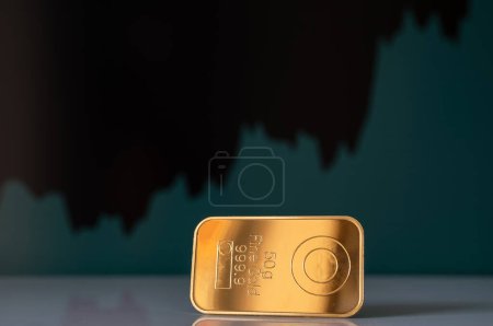 Photo for Gold bar on the background of the growth chart. Selective focus. - Royalty Free Image