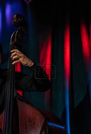 Foto de Hand of the musician on the upright bass at the live concert. Selective focus. - Imagen libre de derechos