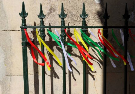 Téléchargez les photos : Rubans colorés sur la clôture métallique d'une vieille église au Portugal. - en image libre de droit