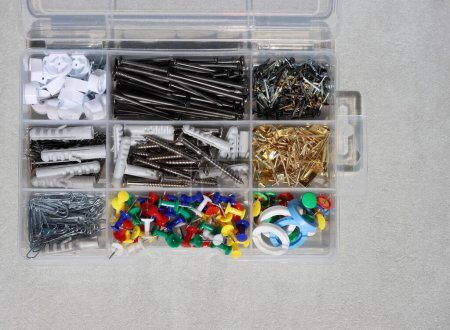 Pequeños accesorios para el hogar en una caja de plástico.