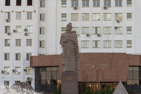 Téléchargez les photos : Atyrau, Kazakhstan (Qazaqstan), 03.09.2023 - Monument au sultan Beybarys. Derrière elle se trouve le bâtiment de l'Akimat de la région d'Atyrau. - en image libre de droit