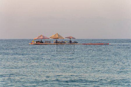 View of the Mediterranean Sea from Cleopatra Beach. Pontoon cafe with umbrellas in the sea. Holidays at sea.