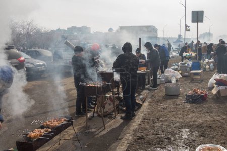 Foto de Uralsk (Oral), Qazaqstan, 22.03.2024 - Nauryz vacaciones en Kazajstán. Cocinar shashlik durante las vacaciones de Nauryz. Humo de barbacoa. - Imagen libre de derechos