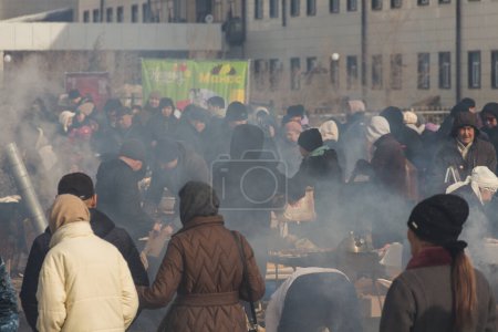 Téléchargez les photos : Uralsk (Oral), Qazaqstan, 22.03.2024 - Vacances à Nauryz au Kazakhstan. Une foule de gens dans la fumée du barbecue. - en image libre de droit