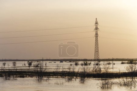 Foto de Inundación en Kazajstán. La ciudad estaba inundada de agua. El río desbordó sus orillas. Derretir el agua en el campo. Soporte de línea eléctrica en agua de inundación. - Imagen libre de derechos