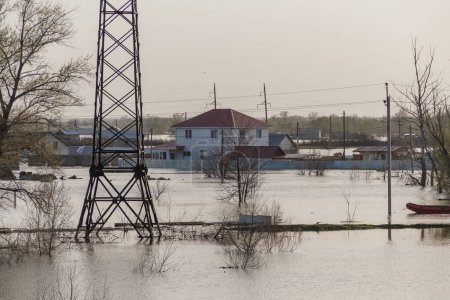 Inundación en Kazajstán. La ciudad estaba inundada de agua. El río desbordó sus orillas. Derretir el agua en el campo. Soporte de línea eléctrica en agua de inundación.
