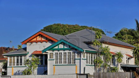 Téléchargez les photos : Maison individuelle de type Queenslander basse en bois avec un toit en tôle ondulée sur des souches verticales en bois avec d'anciennes vérandas fermées dans le centre-ville. Cairns-Queensland-Australie. - en image libre de droit
