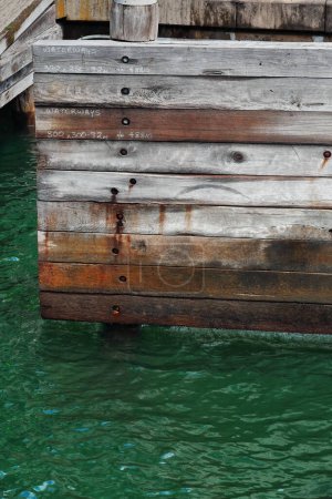 Photo for Wooden buffer stop in the Circular Quay of the City Harbor showing white painted hand notations of measurements for the adjacent waterways crisscrossing the whole bay. Sydney-New South Wales-Australia - Royalty Free Image