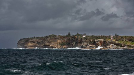 Téléchargez les photos : Le phare de Hornby, classé au patrimoine mondial, le troisième plus ancien phare d'Australie, et les chalets du gardien de phare au sommet de la péninsule de South Head avec ses falaises extérieures battues par les vagues. Sydney-Nouvelle-Galles du Sud. - en image libre de droit